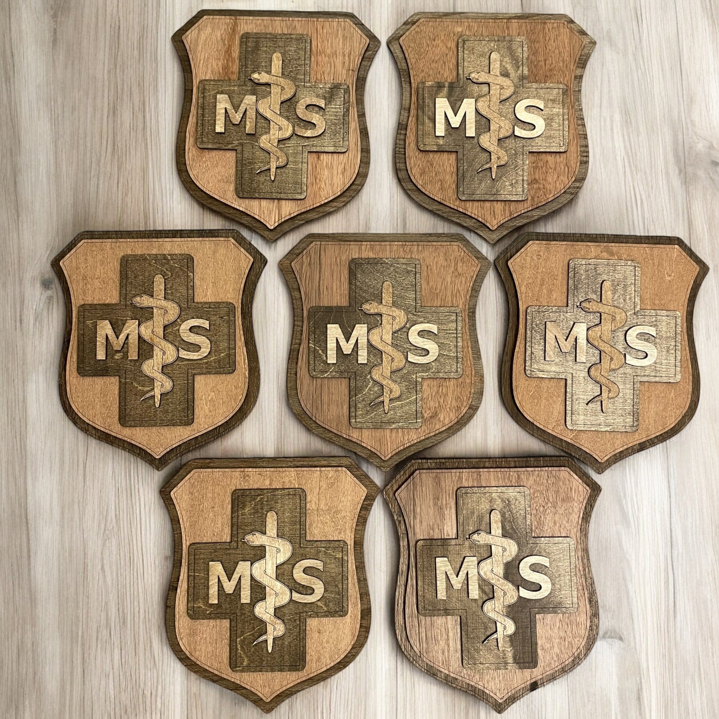 Set of six wooden shields with 'MSS' emblem on a wooden background