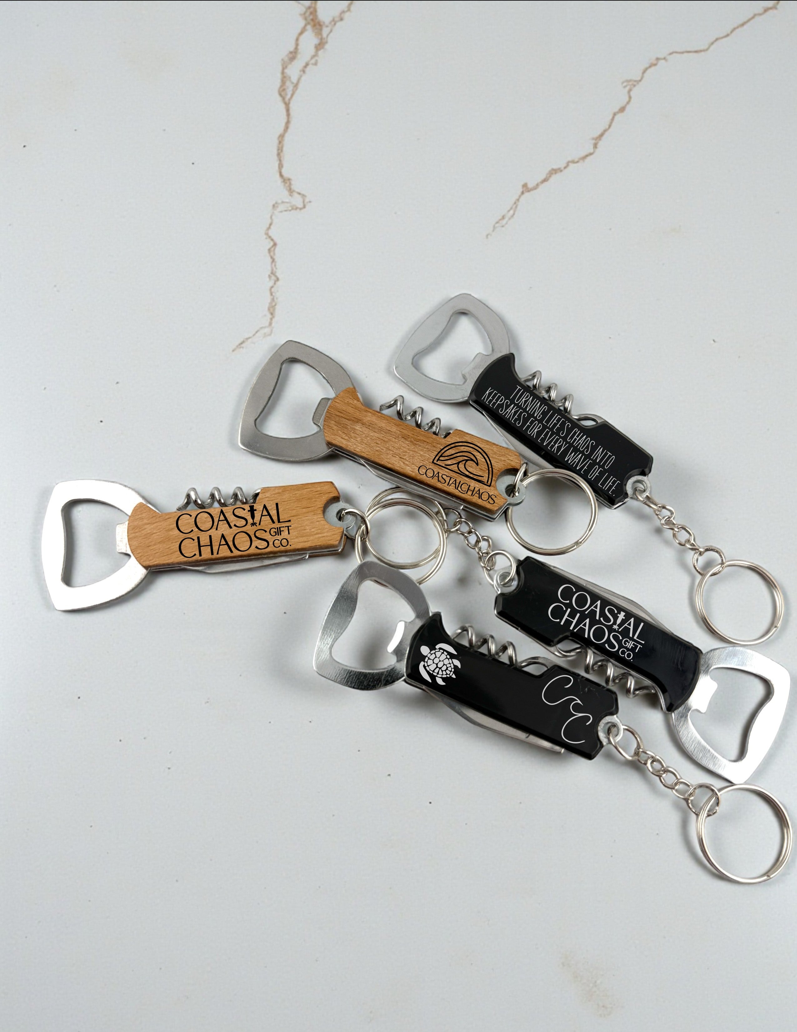 Coastal Chaos Co. custom engraved corkscrew bottle opener keychains in wood and black finishes with multi-tool functionality.