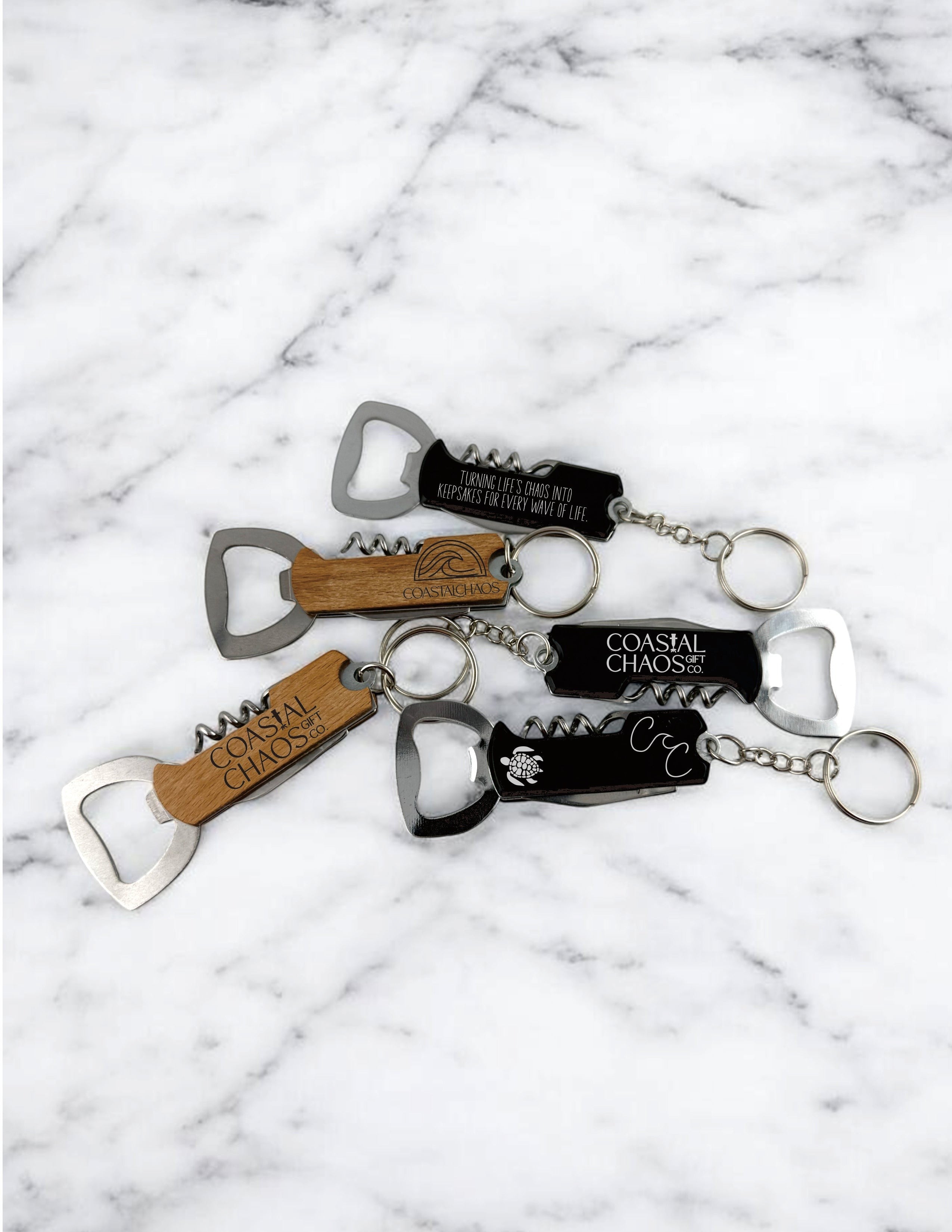 Coastal Chaos Co custom engraved corkscrew bottle opener keychains in wood and black finishes with unique designs.