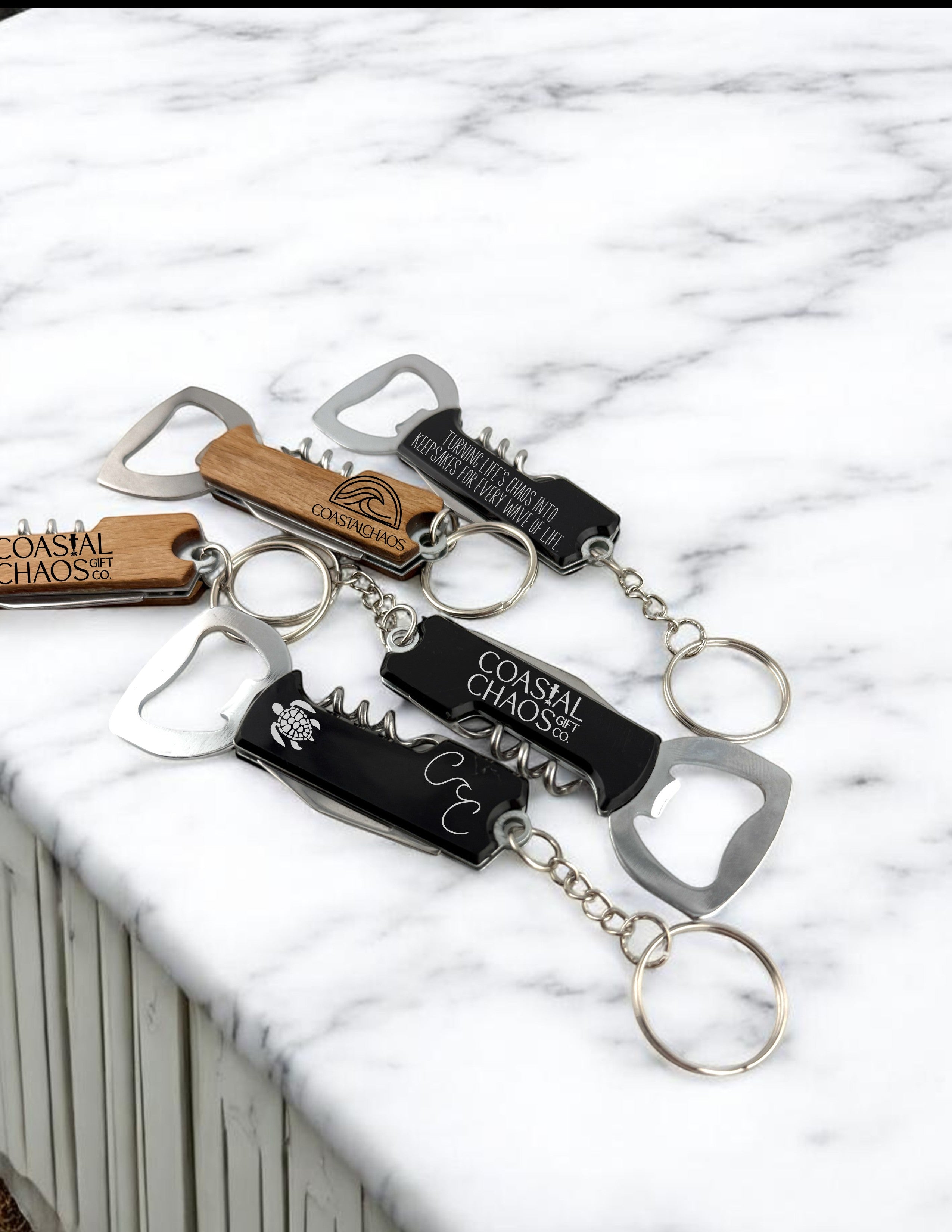 Coastal Chaos Co. engraved multi-tool keychains with corkscrew, bottle opener, and wood or black finishes.