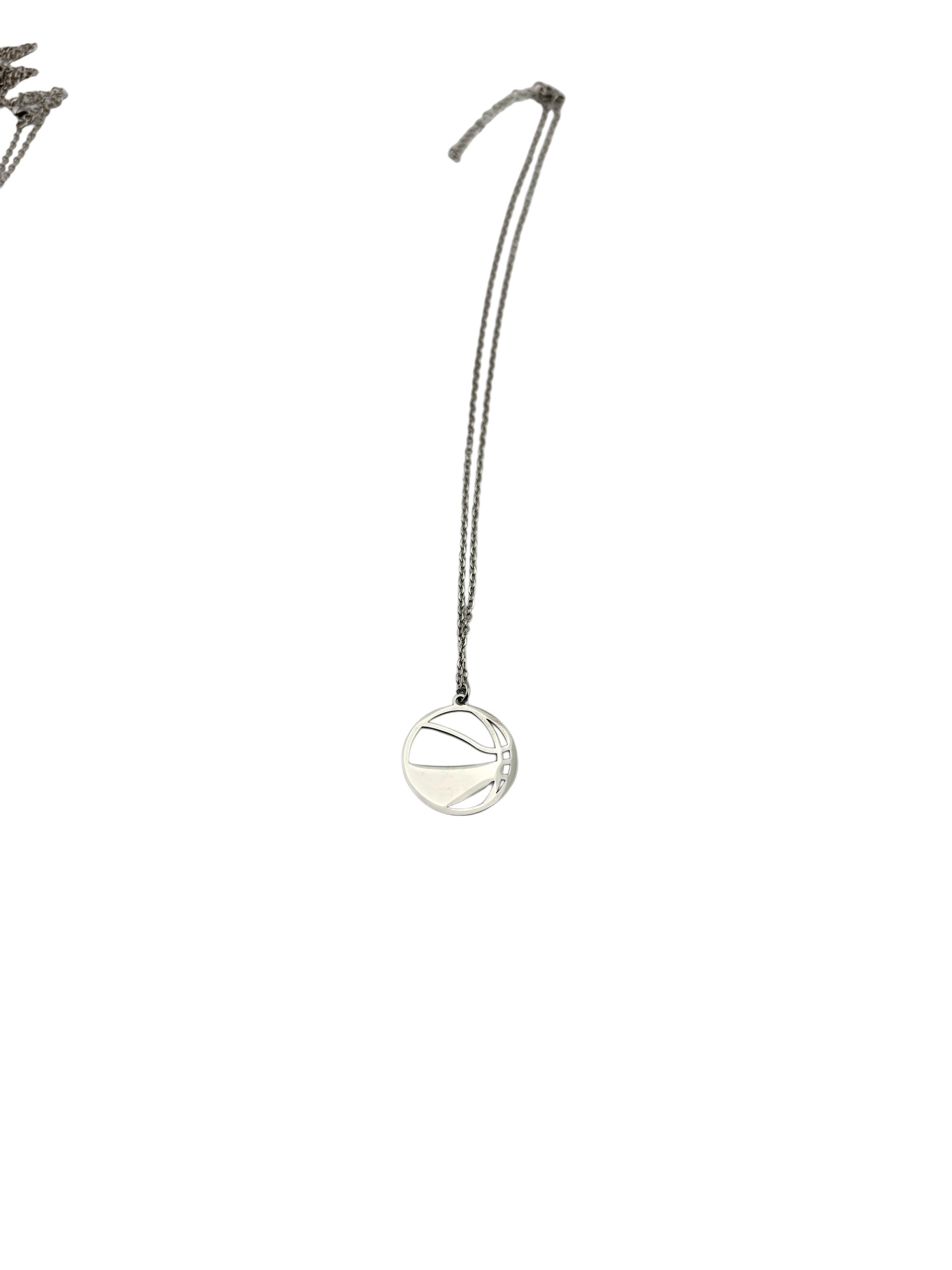 A silver necklace with a round pendant featuring a basketball design hangs from a chain.