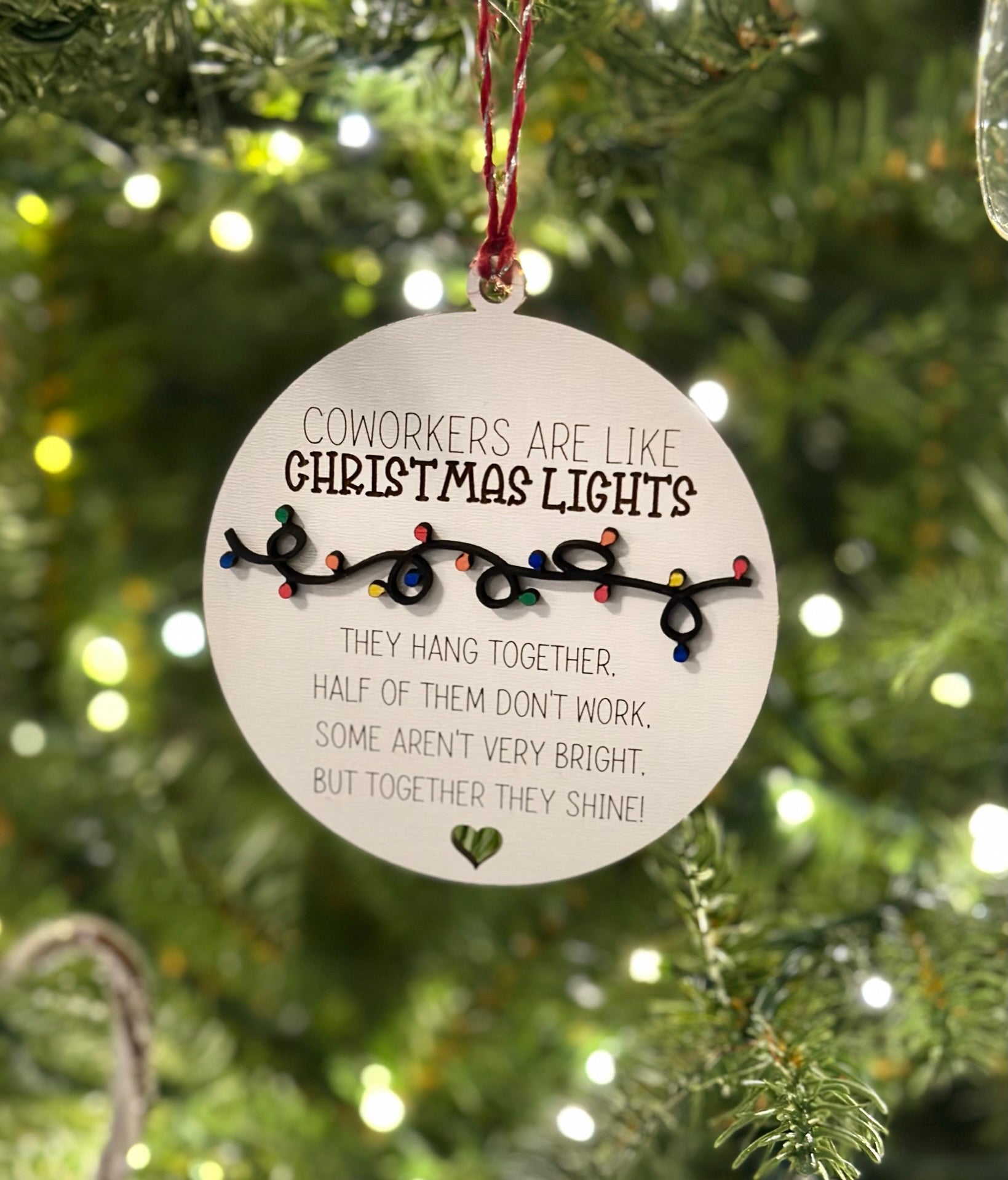 a Christmas ornament hanging on a tree, with a message about coworkers being like Christmas lights.