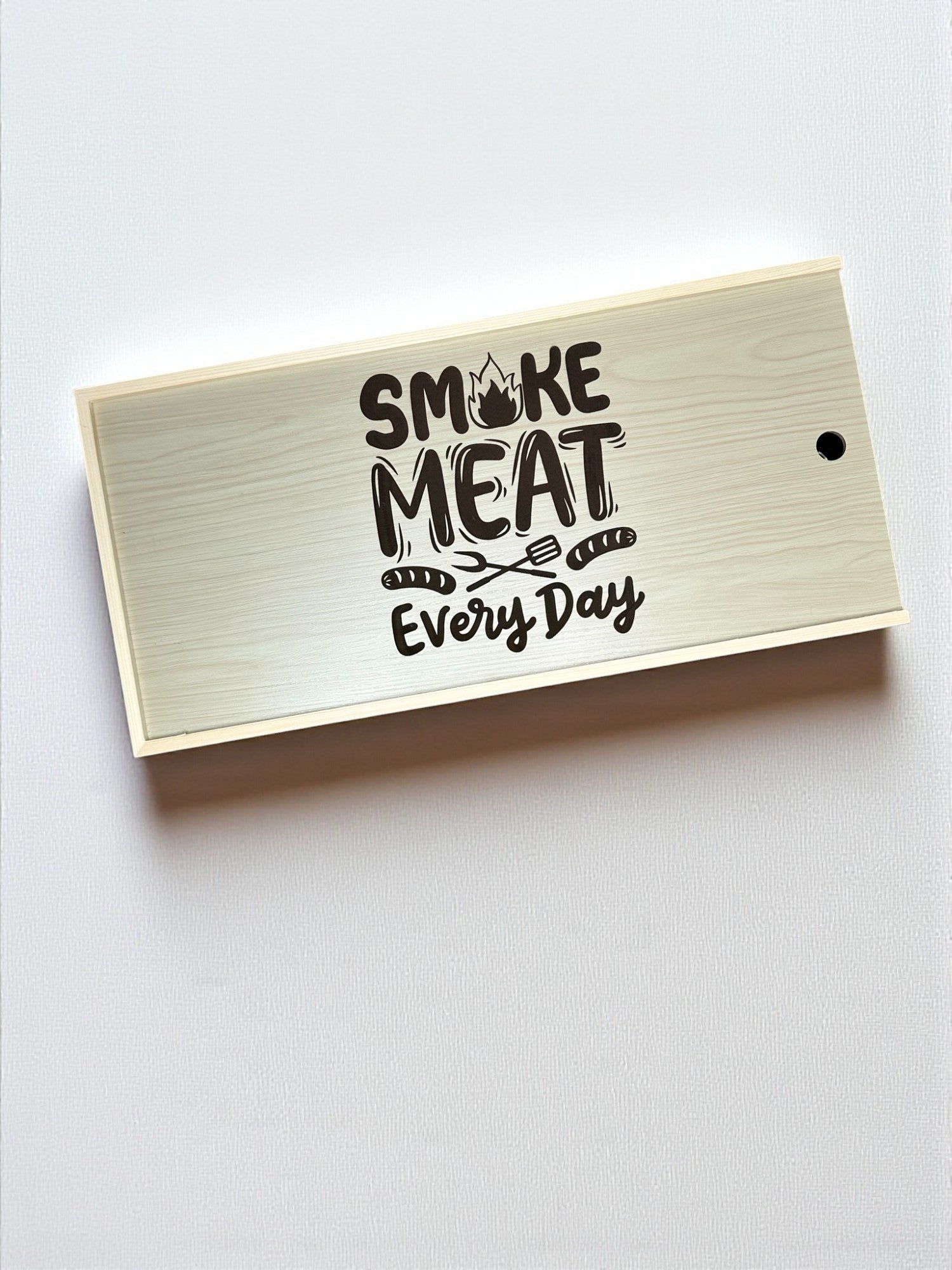 a wooden box with the text "SMOKING MEAT EVERY DAY" printed on it.
