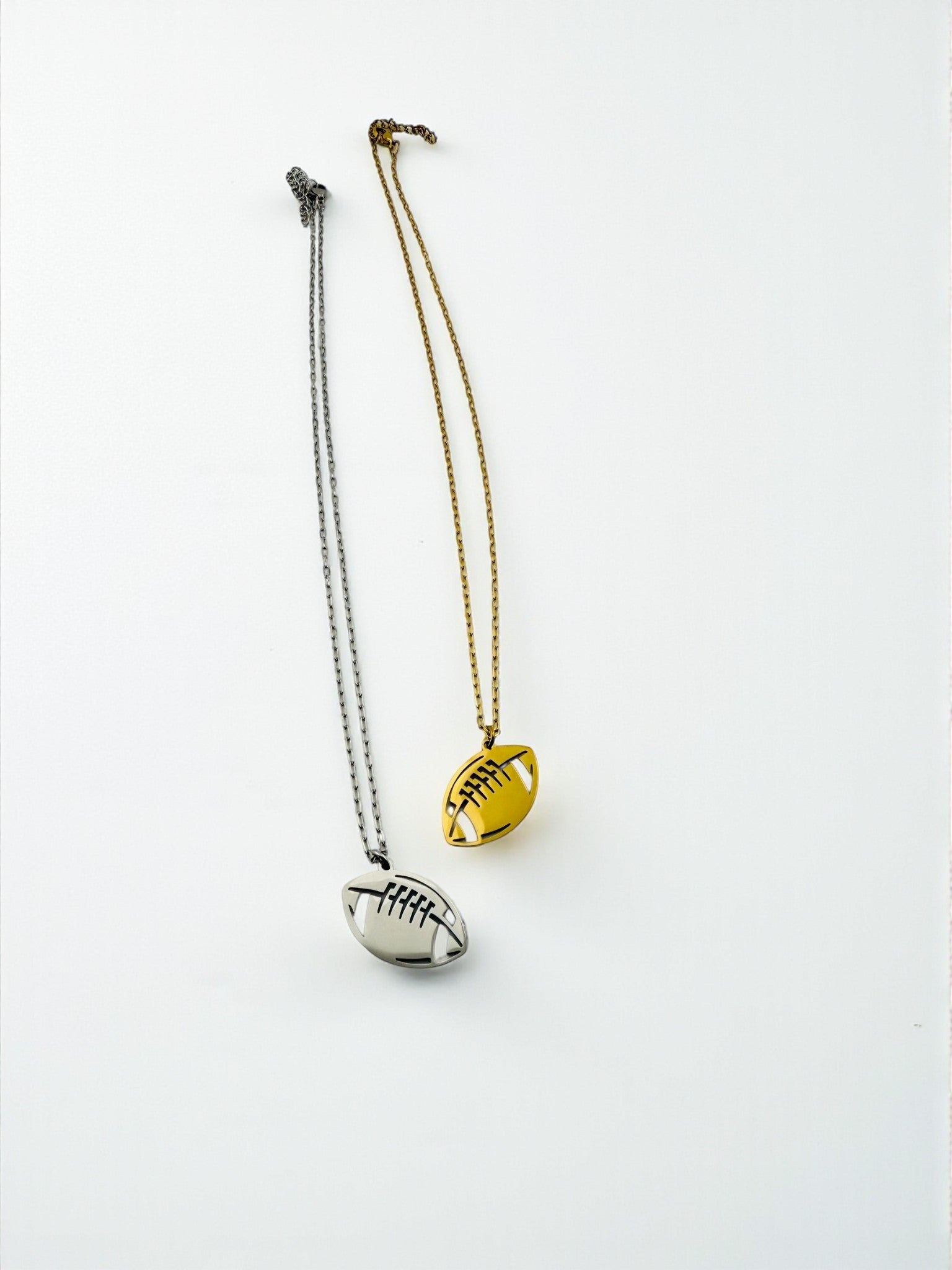 Two necklaces with football pendants on a white background