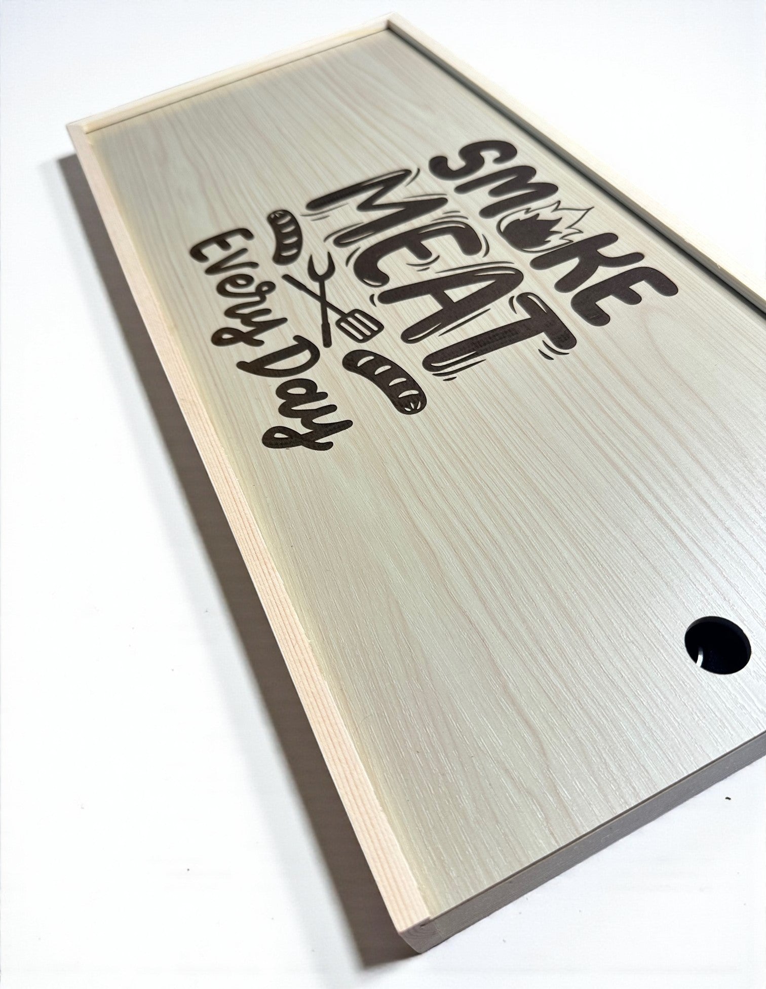a wooden cutting board with the text "Smoke Meat Every Day" printed on it.
