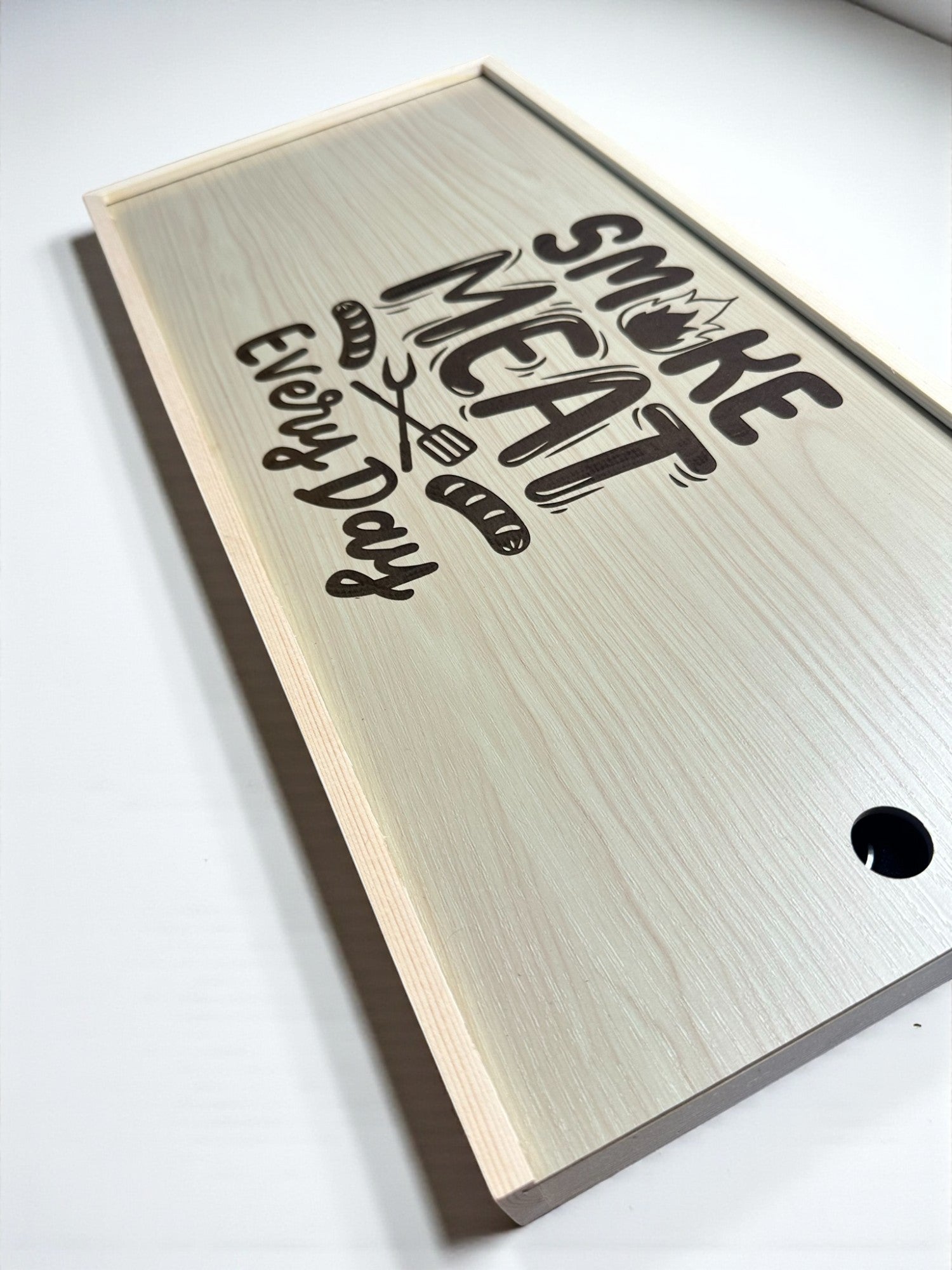 a wooden cutting board with the text "Smoke Meat Every Day" printed on it.