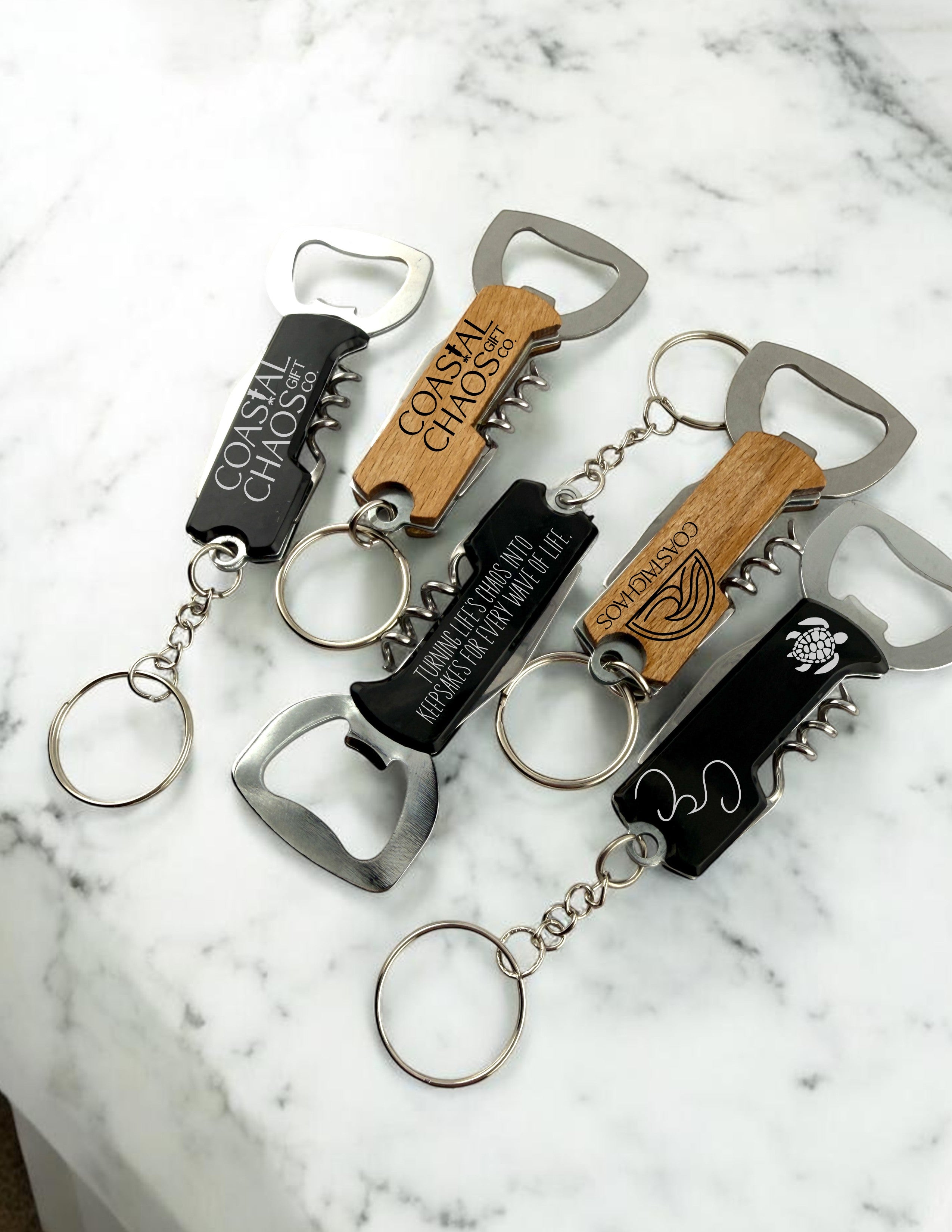 Coastal Chaos Co custom engraved corkscrew bottle opener keychains in black and wood finishes with metal multi-tools.