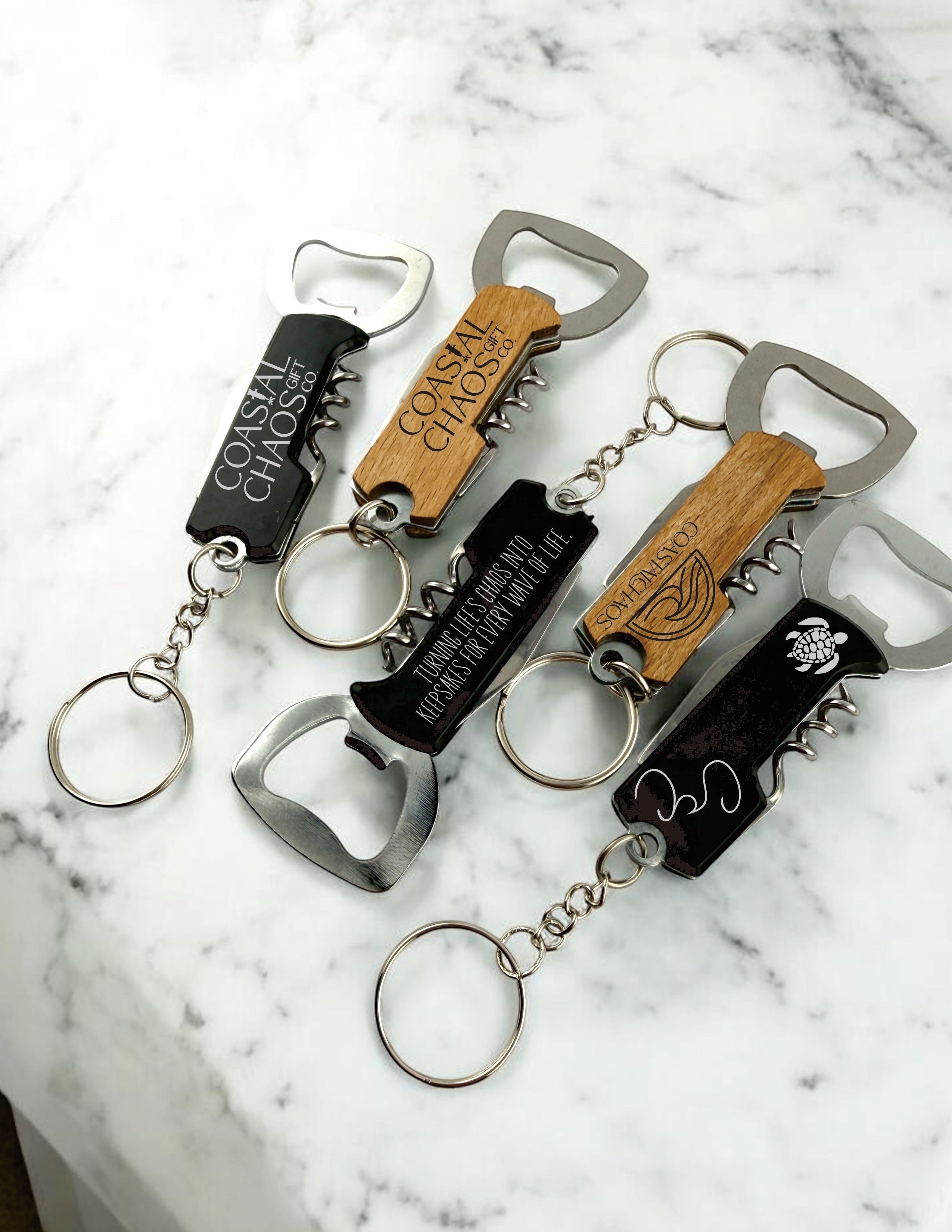 Coastal Chaos Co custom engraved corkscrew bottle opener keychains in black and wood finishes. Features multi-tool functionality.