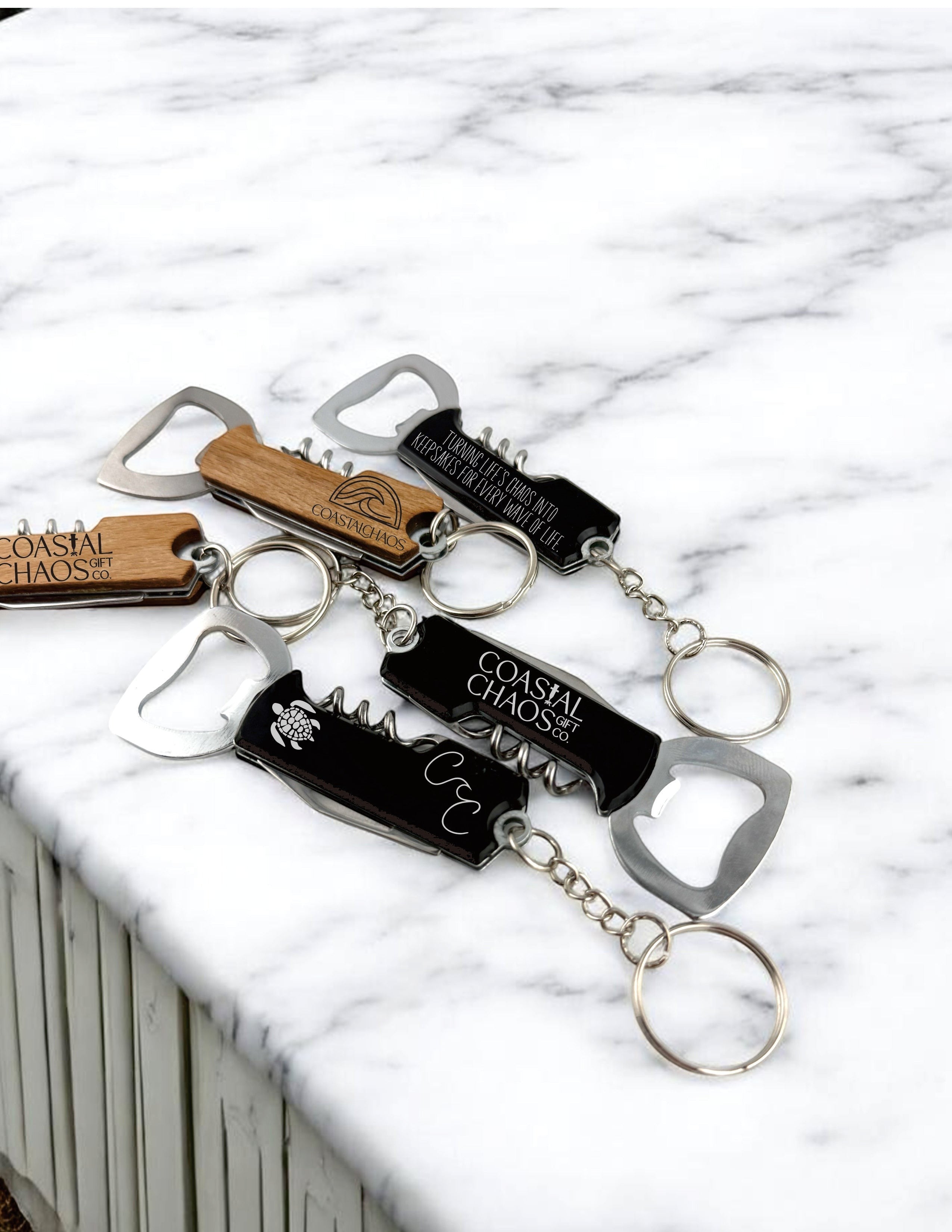 Coastal Chaos Co. engraved multi-tool keychains with corkscrew and bottle opener. Black and wood finishes.