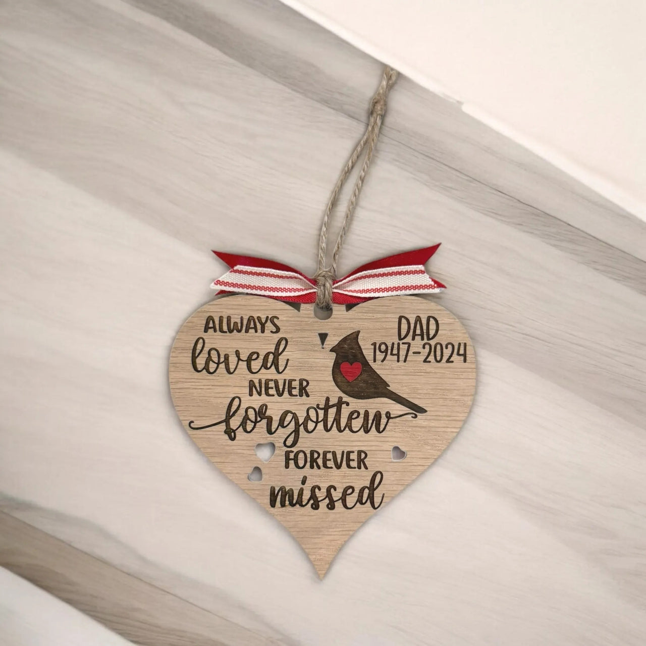 A wooden heart-shaped ornament with a ribbon and a message that says "Always loved never forgot forever missed" and "DAD 1947-2024".