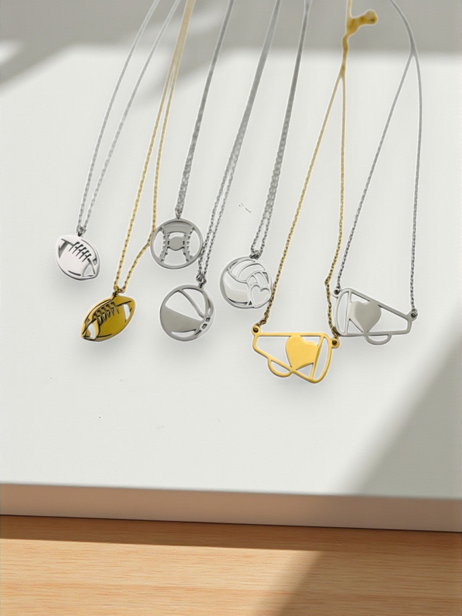 a collection of necklaces with various sports-themed pendants hanging from them.