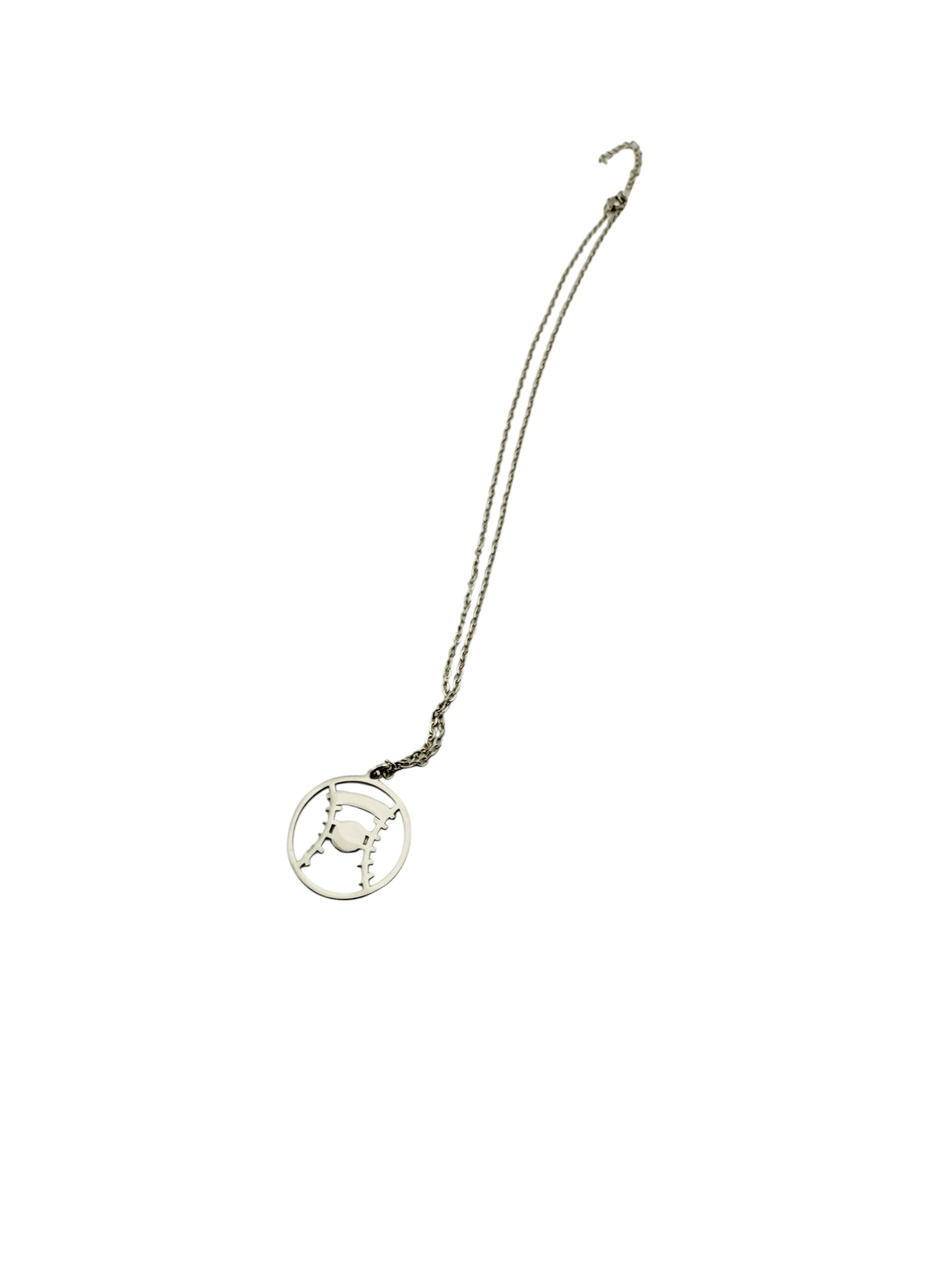A silver necklace with a circular pendant featuring a design resembling a wheel or hub.