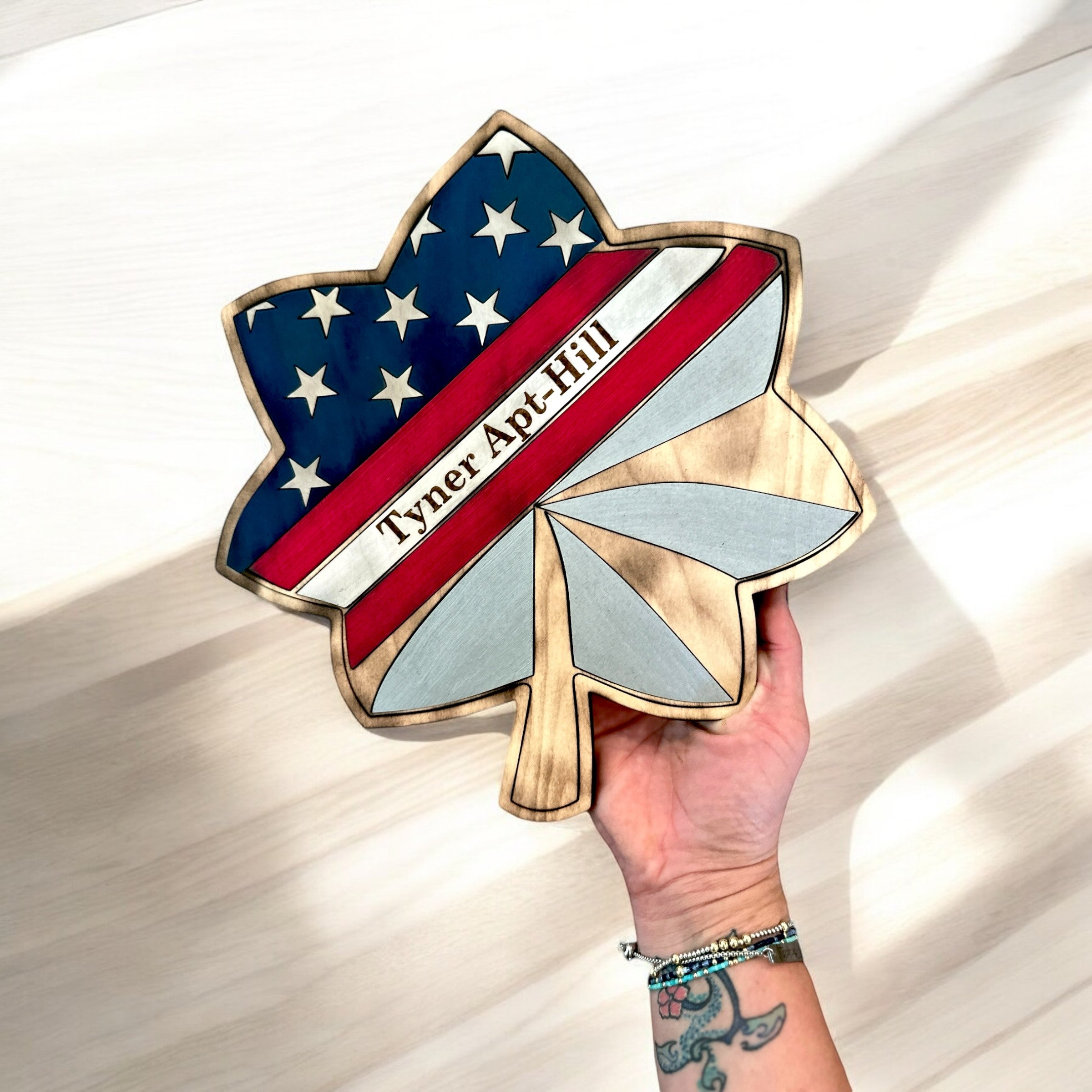 Hand holding a decorative item with American flag design on a wooden surface